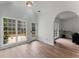 Bright room featuring many windows, a door to the outside, light wood floors, and an arched doorway at 3285 Country Walk Dr, Powder Springs, GA 30127