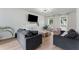 Open living room with a decorative fireplace, neutral sofas, light wood floors, and large windows at 3285 Country Walk Dr, Powder Springs, GA 30127
