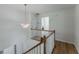 Upstairs landing with a decorative chandelier, wood railing, and light wood floors at 3285 Country Walk Dr, Powder Springs, GA 30127