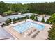Aerial view of a refreshing swimming pool, surrounded by lounge chairs, tennis court and lush greenery at 3285 Country Walk Dr, Powder Springs, GA 30127