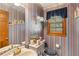 Half bathroom featuring floral wallpaper, window with valance, and single sink at 3472 Honeycomb Se Dr, Conyers, GA 30094