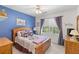 Comfortable bedroom with a queen-sized bed, blue accent wall, and a window that lets in natural light at 3472 Honeycomb Se Dr, Conyers, GA 30094