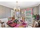 Dining room with floral wallpaper, large windows, and formal table setting at 3472 Honeycomb Se Dr, Conyers, GA 30094