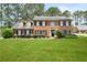 Traditional brick home with manicured lawn and mature trees in a well-maintained community at 3472 Honeycomb Se Dr, Conyers, GA 30094
