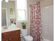 Cozy bathroom with patterned shower curtain, vanity, and decorative mirror with natural light at 4024 Broadmoor Sw Ct, Austell, GA 30106