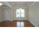 Open dining room with hardwood floors, large window, elegant lighting fixture, and view of the entryway at 4024 Broadmoor Sw Ct, Austell, GA 30106