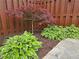 A landscaped garden featuring a Japanese Maple tree, hostas, and a privacy fence at 4024 Broadmoor Sw Ct, Austell, GA 30106