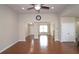 Open living room with hardwood floors, ceiling fan, access to the front entryway, and view of the dining room at 4024 Broadmoor Sw Ct, Austell, GA 30106