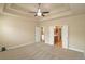 Bright main bedroom featuring tray ceilings, neutral carpet, and access to a luxurious ensuite bathroom at 4024 Broadmoor Sw Ct, Austell, GA 30106