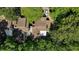 Overhead view of a brown roofed home featuring a large deck space surrounded by lush green trees and some partial parking at 12 Dunwoody Springs Dr # 12, Atlanta, GA 30328
