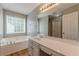 Bright bathroom featuring a large mirror, vanity, and soaking tub at 150 Alton Cir, Villa Rica, GA 30180