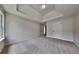 Well-lit bedroom features plush carpet, a tray ceiling, and multiple doors at 4706 Derby Loop, Fairburn, GA 30213