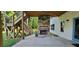 Covered back porch with a stone fireplace, wooden beams, and outdoor staircase at 8 Ripplewood Trl, Euharlee, GA 30145