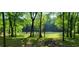 Lush green backyard leading to a tranquil river, framed by towering trees at 8 Ripplewood Trl, Euharlee, GA 30145
