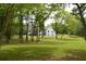 Large backyard featuring mature trees and manicured lawn with views of home at 8 Ripplewood Trl, Euharlee, GA 30145