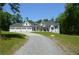 Charming home featuring a three-car garage, manicured lawn, and long driveway at 8 Ripplewood Trl, Euharlee, GA 30145