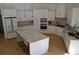 Modern white kitchen featuring stainless steel appliances, a center island with seating, and hardwood floors at 8 Ripplewood Trl, Euharlee, GA 30145