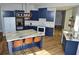 Open kitchen featuring navy cabinets, stainless appliances, granite countertops and a breakfast bar at 8 Ripplewood Trl, Euharlee, GA 30145