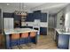 Modern kitchen with blue cabinets, island with marble countertop, and stainless steel appliances at 8 Ripplewood Trl, Euharlee, GA 30145