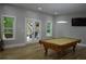 Bright living room with pool table, large windows, and French doors at 8 Ripplewood Trl, Euharlee, GA 30145