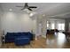 Spacious living room featuring a plush blue sofa, hardwood floors, and an open floor plan at 8 Ripplewood Trl, Euharlee, GA 30145