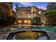 A luxurious pool and spa feature a stone surround, highlighted by ambient lighting and a well-manicured backyard at 1200 Bay Pointe Terr Ter, Alpharetta, GA 30005