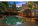 Beautiful pool with integrated spa and stone patio lit up at dusk, creating an inviting outdoor retreat at 1200 Bay Pointe Terr Ter, Alpharetta, GA 30005
