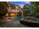 A pristine pool and spa are surrounded by a stone patio, complemented by ambient string lights and mature landscaping at 1200 Bay Pointe Terr Ter, Alpharetta, GA 30005