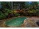 A stunning backyard pool and spa are surrounded by lush landscaping and a stone patio, perfect for relaxation at 1200 Bay Pointe Terr Ter, Alpharetta, GA 30005