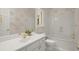 Clean, white bathroom with decorative wallpaper, tub and vanity with marble countertop at 1200 Bay Pointe Terr Ter, Alpharetta, GA 30005