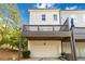 Townhome exterior featuring a private garage and a charming balcony overlooking the yard under a blue sky at 1405 Attwater Dr, Atlanta, GA 30316