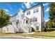 Exterior elevation of townhomes with white staircases and covered porch entries in a green community setting at 1405 Attwater Dr, Atlanta, GA 30316