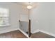 Landing with hardwood floors, a window with blinds, wooden and black railing, overhead lighting and a white door at 1405 Attwater Dr, Atlanta, GA 30316