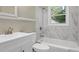 Modern bathroom featuring white marble-style tiling, updated sink and vanity, and a shower-tub combo at 1849 Broad Ave, Atlanta, GA 30344