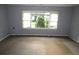 Empty living room featuring neutral paint, a large window, and worn carpet flooring at 2172 Jernigan Drive Se, Atlanta, GA 30315