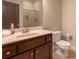 Well-lit bathroom featuring a solid surface vanity top, wood cabinets, and glass shower doors at 2664 Long Pointe, Johns Creek, GA 30076