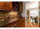 Butler's pantry featuring custom cabinets, granite counters, mosaic backsplash, and wine storage at 2664 Long Pointe, Johns Creek, GA 30076