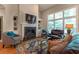 Cozy living room with a fireplace, large windows, and comfortable seating, ideal for relaxing and entertaining at 2664 Long Pointe, Johns Creek, GA 30076