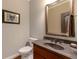 Tastefully decorated powder room with cherry vanity, granite countertop, framed mirror, and wood floors at 2664 Long Pointe, Johns Creek, GA 30076