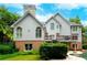 Charming two-story home showcasing a spacious deck, manicured lawn, and a serene backyard retreat with mature trees at 1000 Admiral Xing, Alpharetta, GA 30005