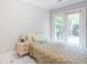 Cozy bedroom with a comfortable bed, a nightstand, and a view of the outdoor area through French doors at 1000 Admiral Xing, Alpharetta, GA 30005