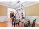 Elegant dining room with glass table, wainscoting, and view to the kitchen and staircase at 1000 Admiral Xing, Alpharetta, GA 30005