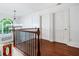 Upstairs hallway with hardwood floors, white trim, staircase, and arched window with a view at 1000 Admiral Xing, Alpharetta, GA 30005