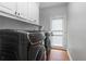 Modern laundry room with cabinets, wooden floors, and a door leading to the outside at 1000 Admiral Xing, Alpharetta, GA 30005