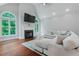 Bright living room featuring a fireplace, hardwood floors, large windows, and a comfortable, sectional couch at 1000 Admiral Xing, Alpharetta, GA 30005
