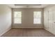 A bright bedroom featuring neutral walls, carpet, and two windows at 1013 Odelle Cir, Mcdonough, GA 30253