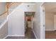 Bright hallway with hardwood floors, leading to the kitchen and staircase with white railings at 1013 Odelle Cir, Mcdonough, GA 30253