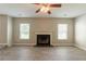 Large living room with fireplace and ceiling fan, features wood flooring and natural light at 1013 Odelle Cir, Mcdonough, GA 30253