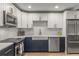 Updated kitchen features stainless appliances, farmhouse sink, subway tile backsplash, and contrasting navy cabinets at 1105 Clairemont Ave # O, Decatur, GA 30030