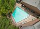 Aerial view of a pristine community pool surrounded by lush greenery and brick buildings at 1105 Clairemont Ave # O, Decatur, GA 30030